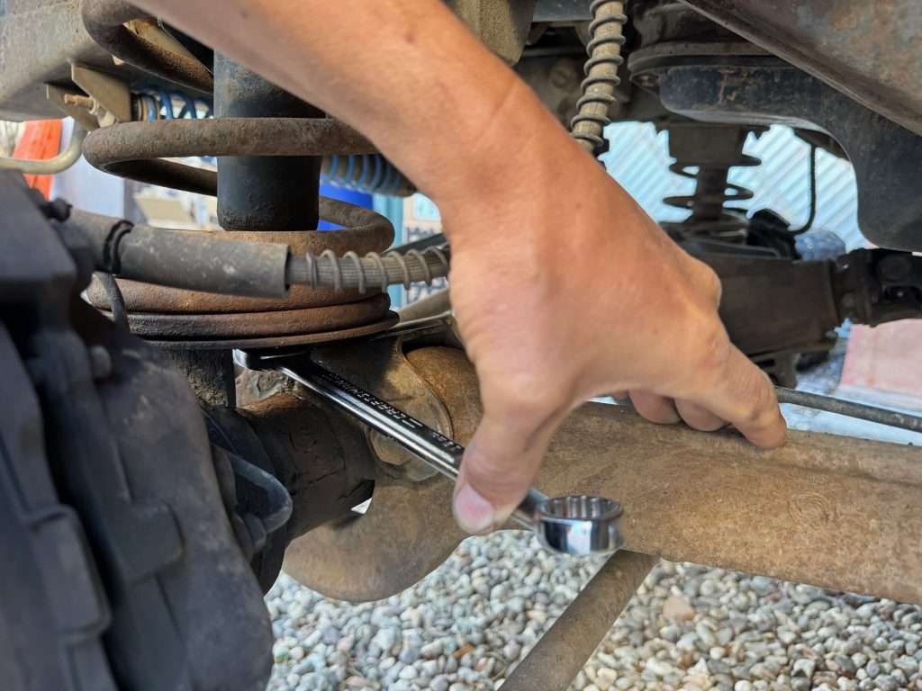 First step, aside from putting the front end up on jack stands and pulling the wheels is unbolting the shock at the bottom. Best to support your axle because it will drop.