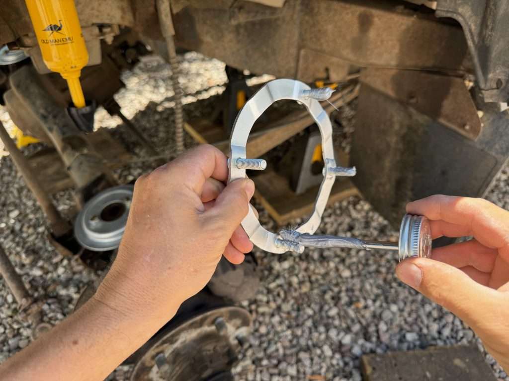 Applying anti-seize to the upper spring seat stud plate for the front suspension of the Land Rover Defender 110