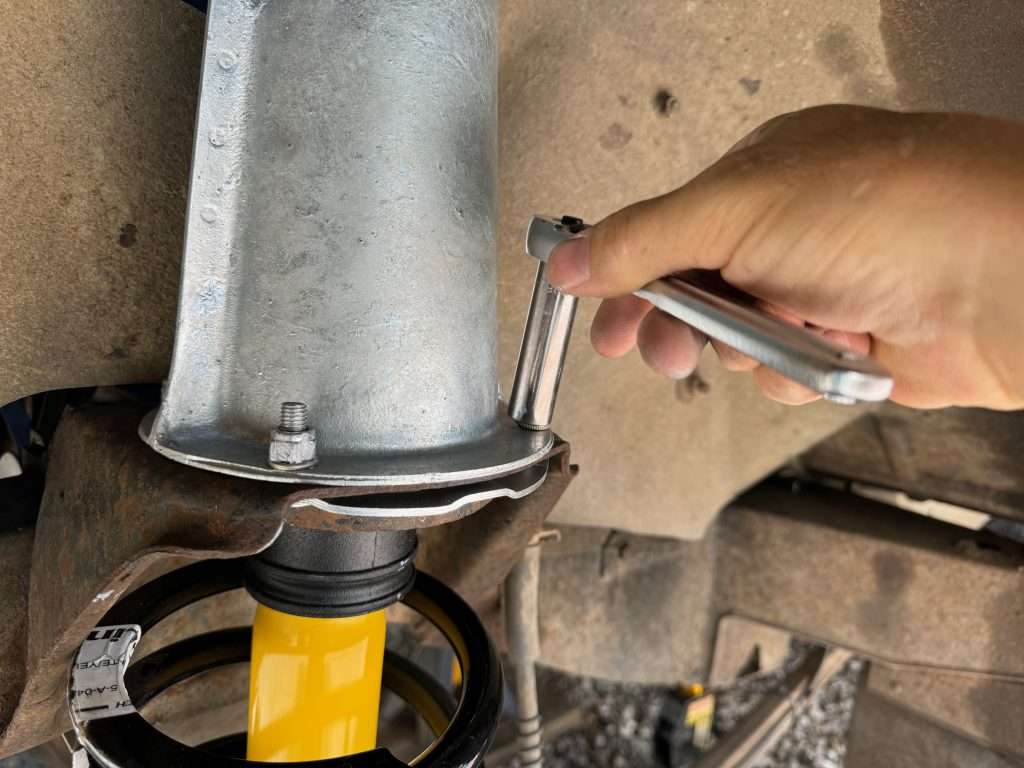 Attaching the shock tower to the top of the upper spring seat in the front of a Land Rover Defender 110