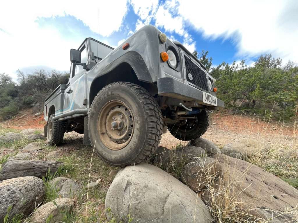 Land Rover Defender 110 posing on some rocks with the wide lens