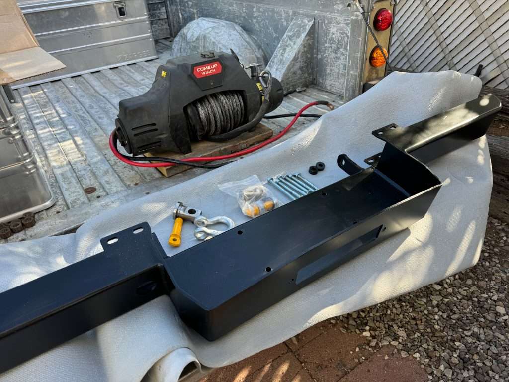 COMEUP Winch and Defender winch bumper all laid out on the bed of the Hi-Cap, ready to install