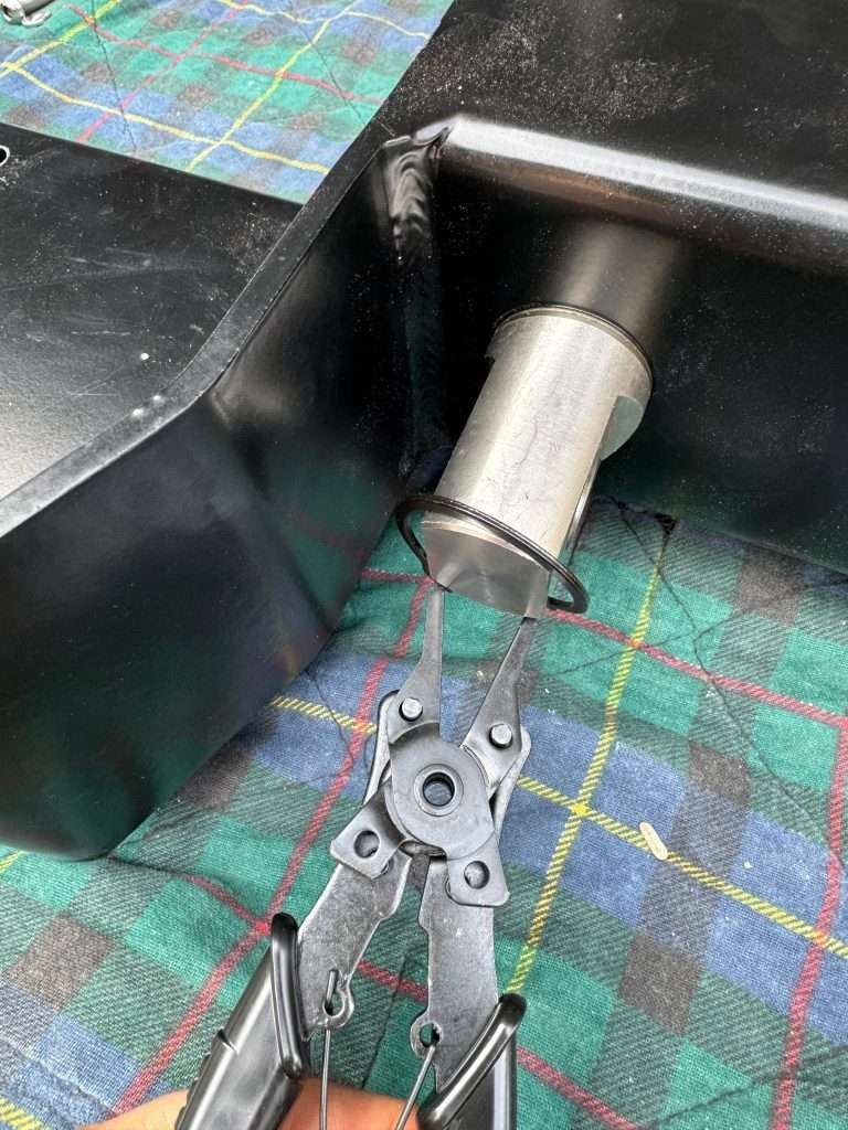 With snap ring pliers, install the stubborn snap ring at the base of the swivel shackle