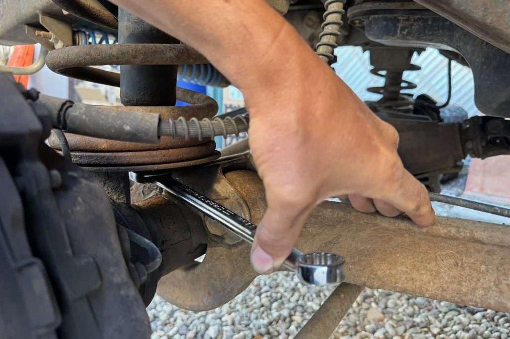 First step, aside from putting the front end up on jack stands and pulling the wheels is unbolting the shock at the bottom. Best to support your axle because it will drop.