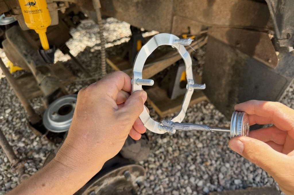 Applying anti-seize to the upper spring seat stud plate for the front suspension of the Land Rover Defender 110