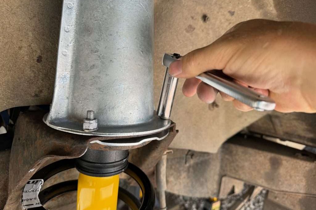 Attaching the shock tower to the top of the upper spring seat in the front of a Land Rover Defender 110