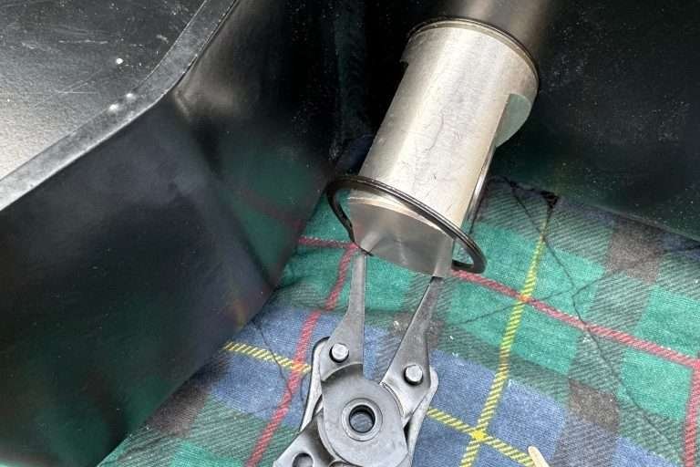 With snap ring pliers, install the stubborn snap ring at the base of the swivel shackle