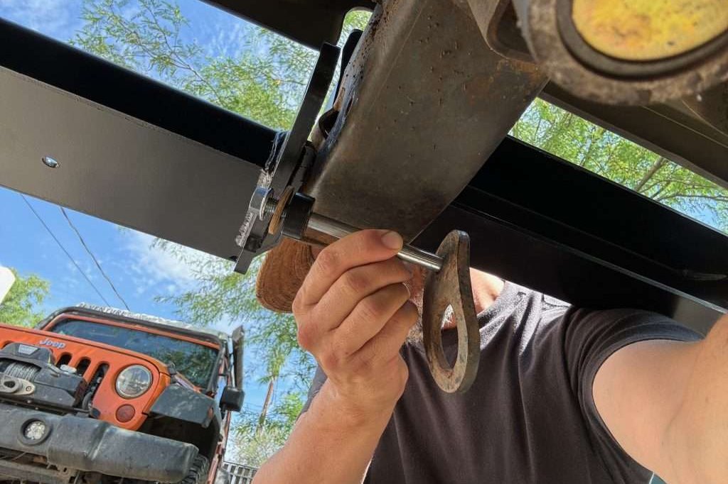 The lower horizontal bolt for the Defender winch bumper utilizes the bolt hole used to secure the tie down loop