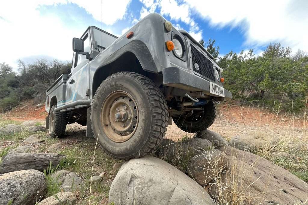 Land Rover Defender 110 posing on some rocks with the wide lens